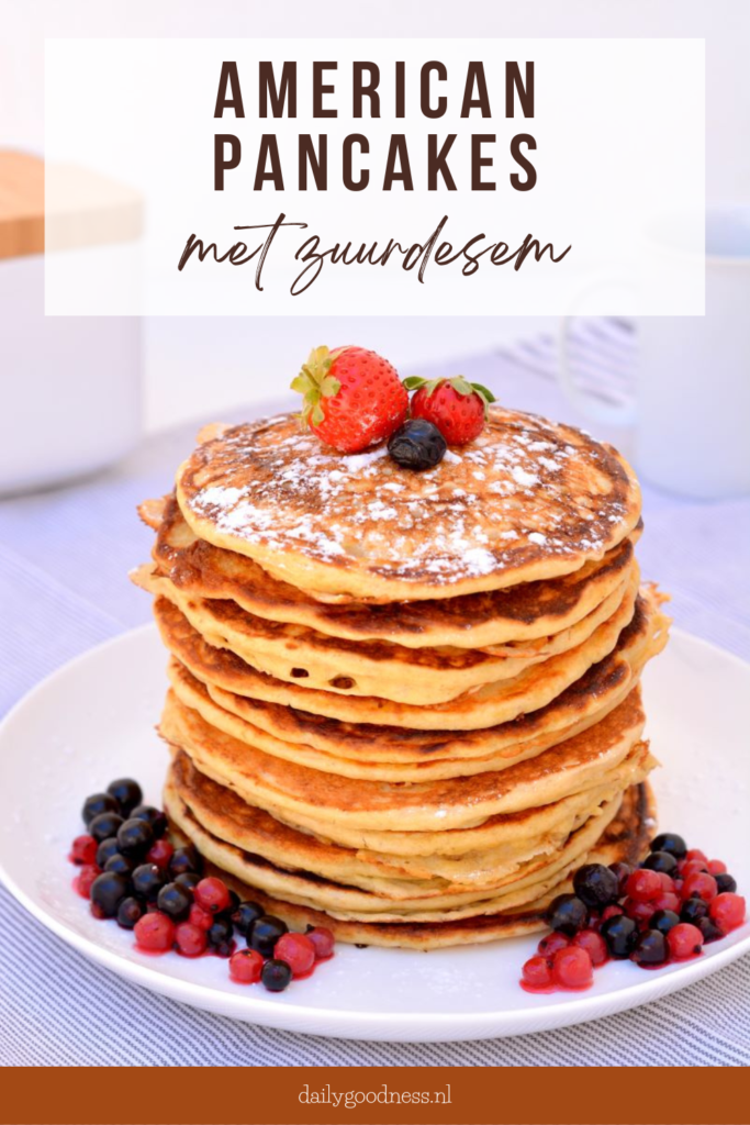 Stapel versgebakken American Pancakes met zuurdesem op een wit bord gedecoreerd met rood fruit