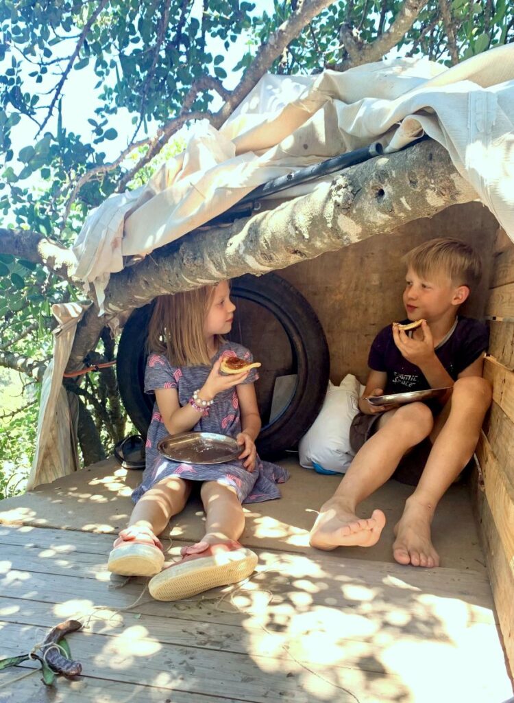 Twee kinderen zitten in een boomhut American Pancakes te eten