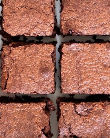 Gesneden versgebakken brownies liggen op wit keukenblad