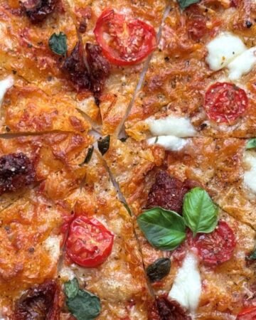 Versgebakken zuurdesem pizza ligt in gesneden punten op bakpapier