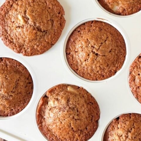 Versgebakken 100% volkoren spelt muffins met appel staan in een witte PFAS-vrije muffinvorm van GreenPan af te koelen