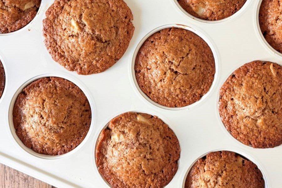 Versgebakken 100% volkoren spelt muffins met appel staan in een witte PFAS-vrije muffinvorm van GreenPan af te koelen