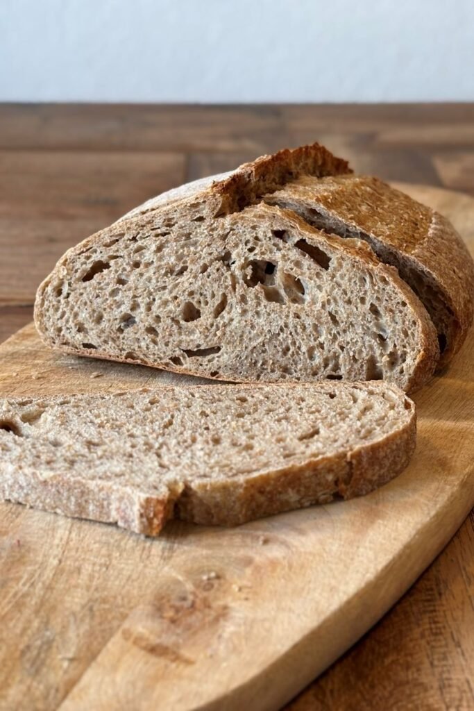 Gesneden volkoren brood ligt op een plank op de eettafel.