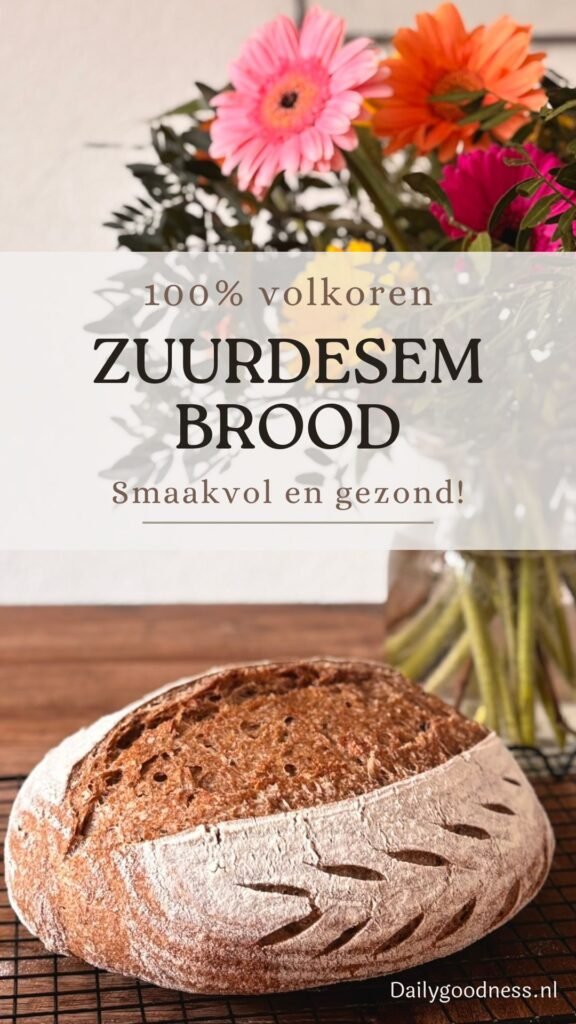 Versgebakken volkoren zuurdesem brood ligt op afkoelrooster voor een vaas met bloemen op houten tafelblad