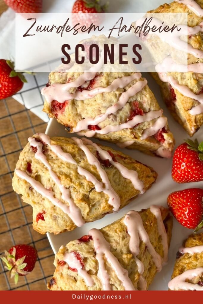 Versgebakken zuurdesem aardbeien scones met aardbeien icing liggen af te koelen op afkoelrooster 