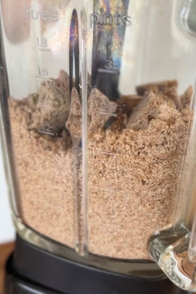 Oude stukken brood worden tot broodkruimels fijngemalen in een Magimix blender om broodkruim te maken.