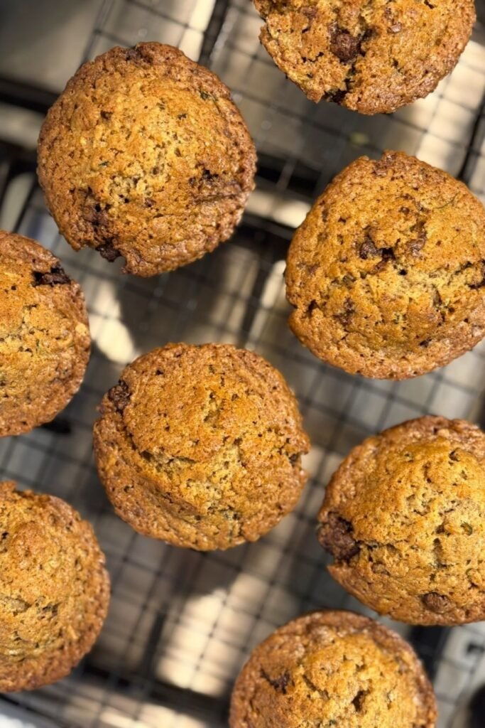 Versgebakken courgette muffins met chocolate chips liggen af te koelen op een afkoelrooster