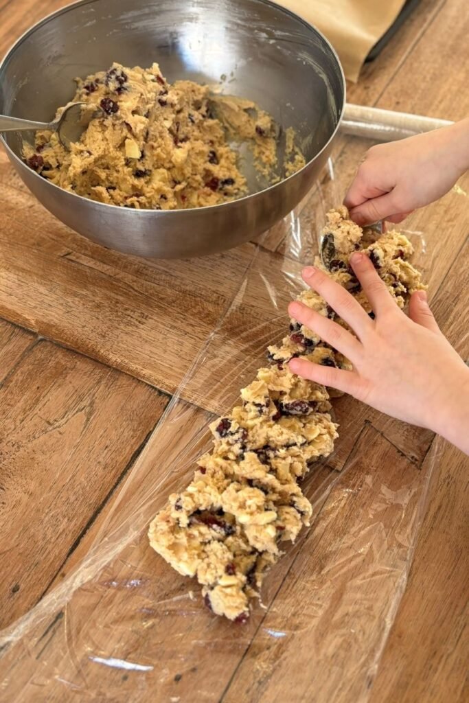 Deeg voor cranberry koeken met witte chocolade wordt op plastic folie gelegd
