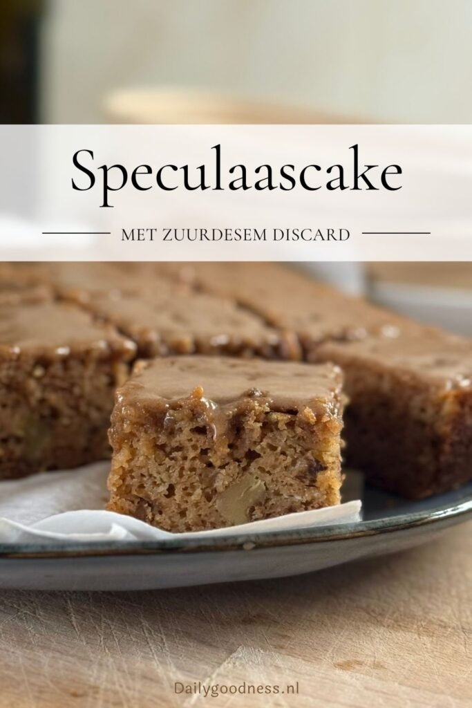 Versgebakken speculaascake met speculaas icing ligt in gesneden blokjes op een presenteerschaal.