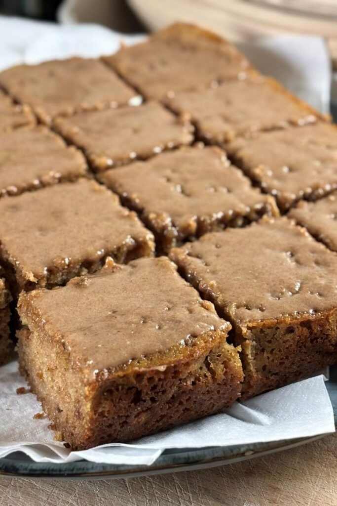 Versgebakken zuurdesem discard speculaas cake met speculaas icing ligt op een bord met servet