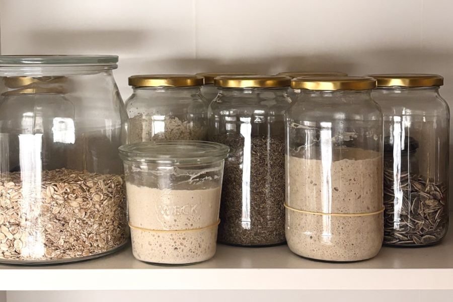 potten met zuurdesem starter staan in de voorraadkast