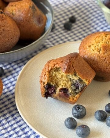 Versgebakken muffins met blauwe bessen liggen op een bord klaar om opgegeten te worden