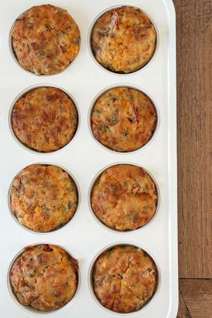 Hartige taartjes in muffinvorm liggen op een houten tafelblad af te koelen