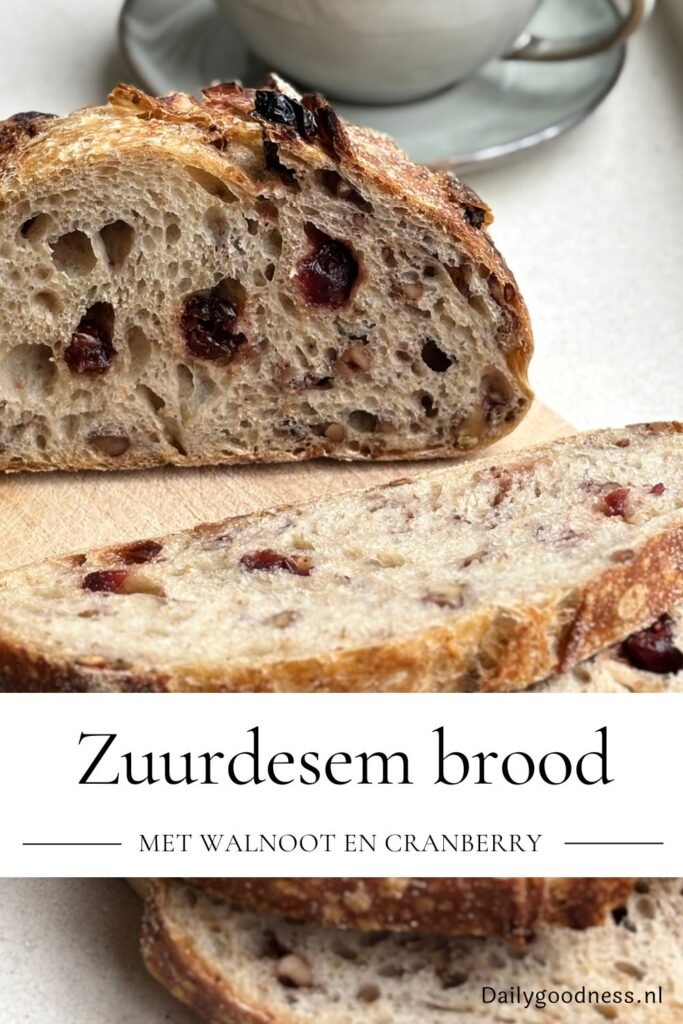 Versgebakken zuurdesem walnoot cranberry brood ligt gesneden op een houten plank
